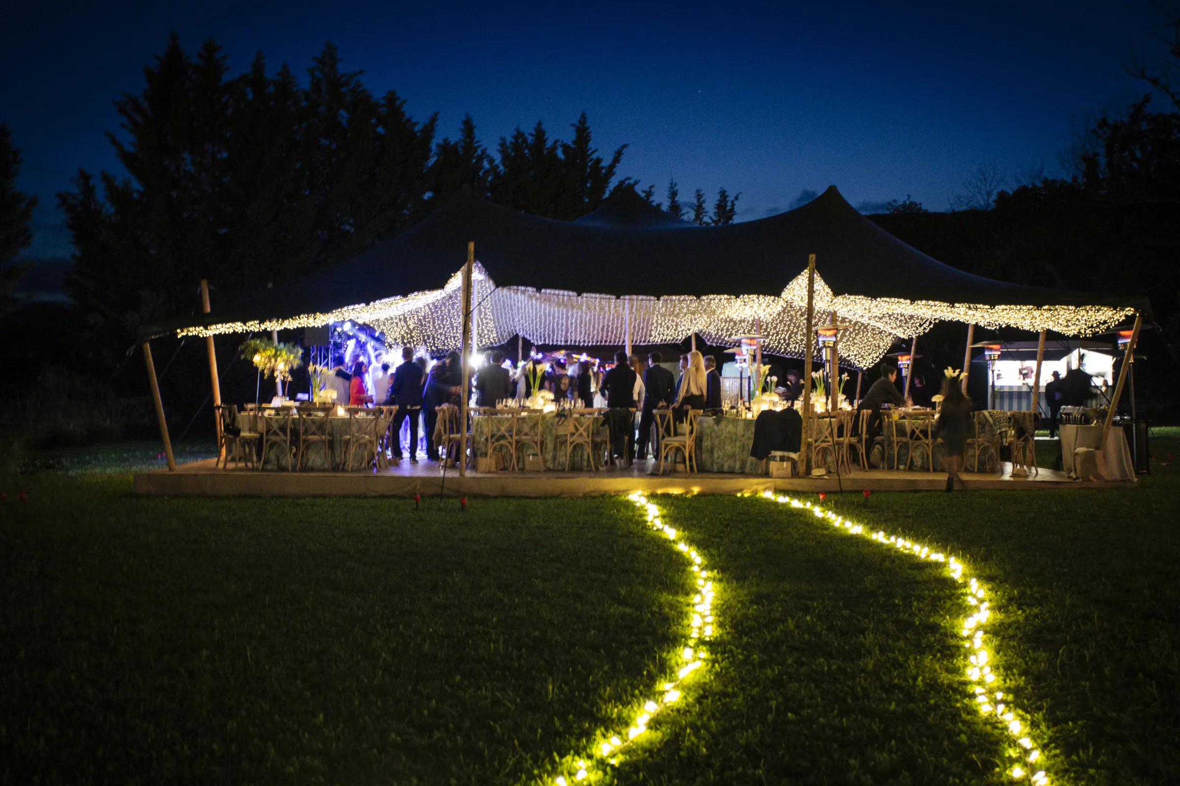 Illuminated gold scallop wall with warm-lit dessert stations